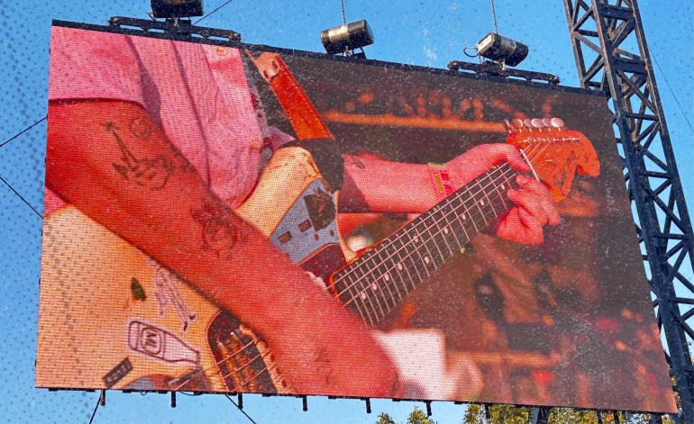 A photo of Royel Maddell, lead guitarist of Royel Otis, displaying his signature white Fender Jazzmaster while performing “Sofa King" 