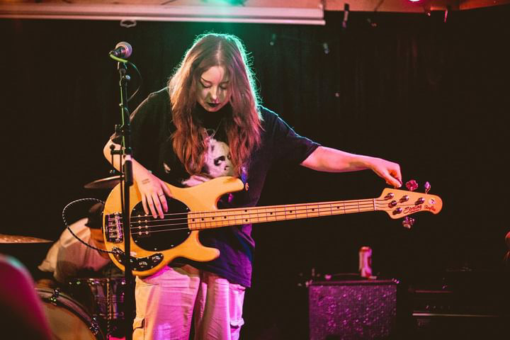 lead singer of ladyluck on stage tuning her guitar