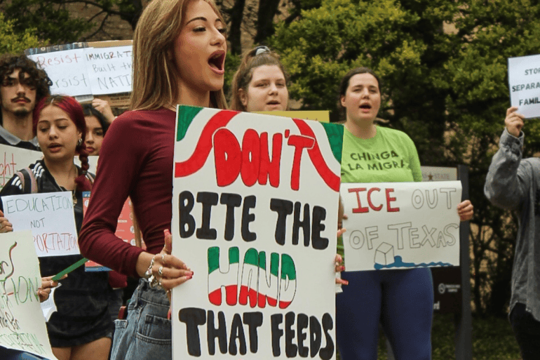 Students hold protest signs advocating for immigration rights
