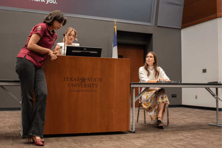 Vice Presidential candidate, Emma Stampley, listens to a questions being asked at the podium by Emma Vega, sustainability director on Bobcats First campaign. 