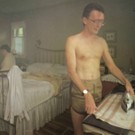 The album cover for “Men I Trust’s” album Equus Asinus. The cover features a shirtless man ironing a towel in a bedroom.