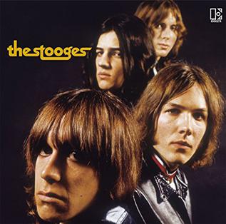 The Stooges self titled album cover. Features the members portraits with a black background and yellow text.