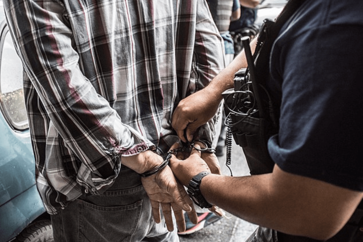 The suspect is put into handcuffs by an Immigration and Customs Enforcement's, Enforcement and Removal Operations officer.
