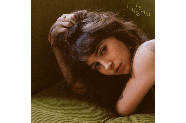  The album cover is a photograph of Clairo laying on a green couch. She is looking at the camera over her shoulder. 