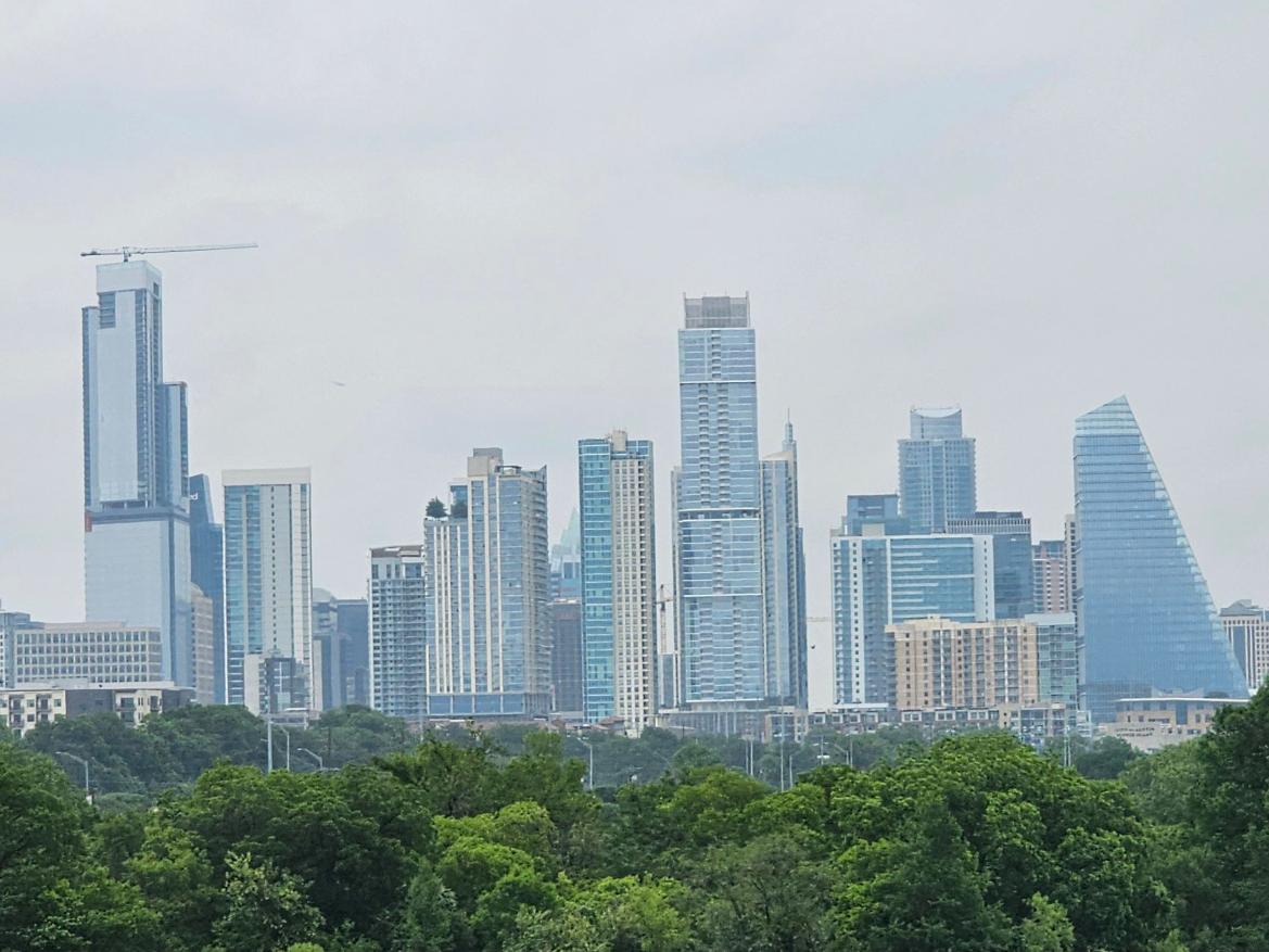 A panoramic view of downtown Austin Texas showing modern skyscrapers under a cloudy sky.