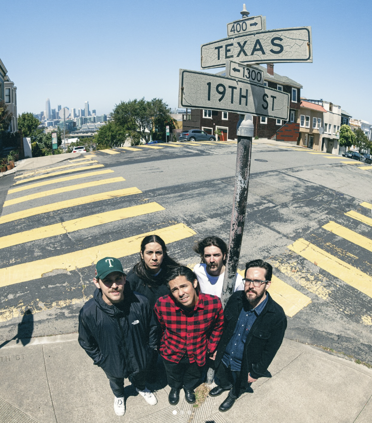 All five members of Trauma Ray pictured in broad daylight, posted next to a street sign at a street corner that reads, “400 TEXAS” and underneath “1300 19TH ST.” 