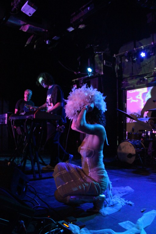 Lead singer of Alma Muneca adjusting a wig