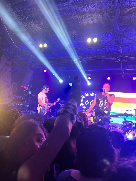 Crowd of people watching band perform on stage 