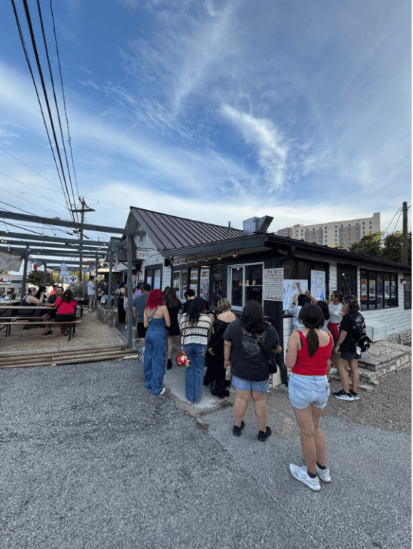 A long line of customers waits outside Howdy Boba
