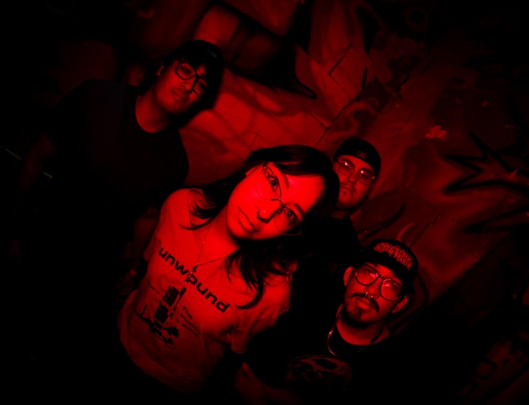 A photo of the band, Cuerno TX, taken with a wide lens. The dominating color of the photo is red.