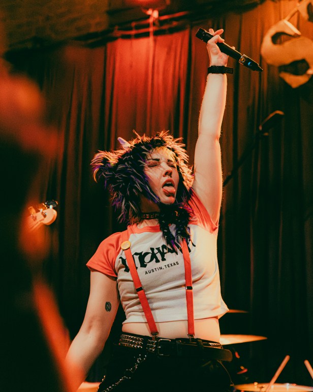 Lead vocalist in CorMae raising their hand up while making a face
