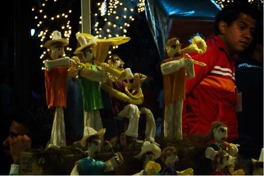 Small figurine musicians playing under the dark night.