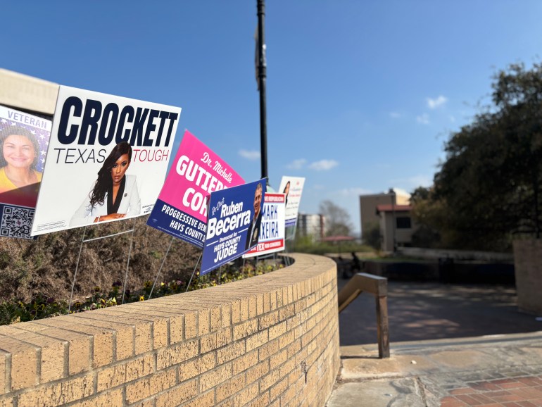 A variety of election candidate signs are posted outside the LBJ Student Center, which include multiple candidate signs posted along the brick wall.