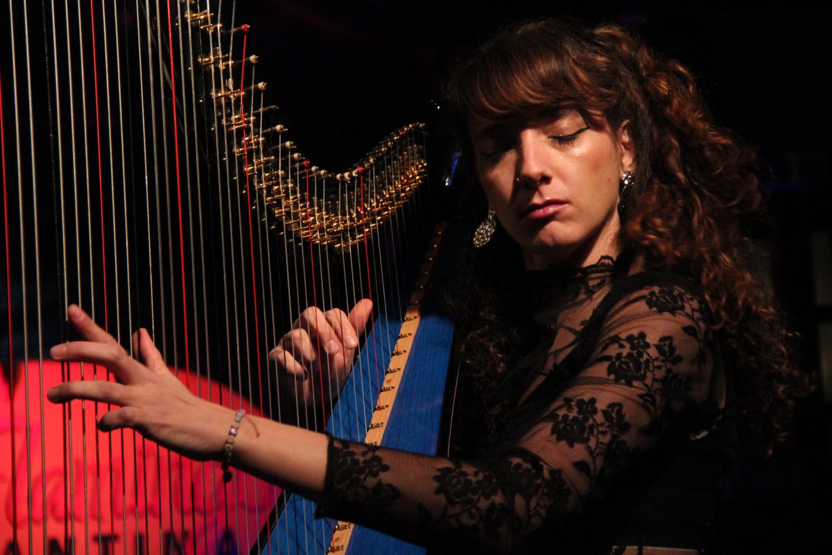 Kety Fusco playing the harp with her eyes closed.