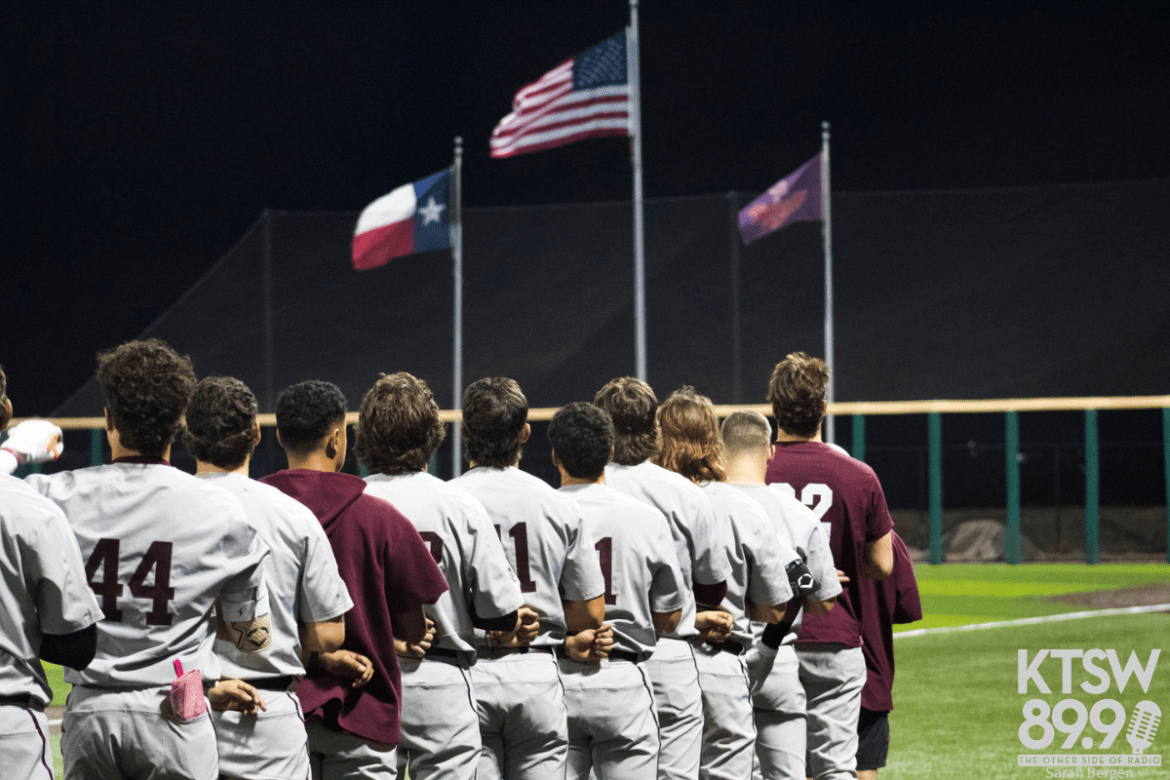 Texas State players are lined up along the first base line for the national anthem before first pitch.