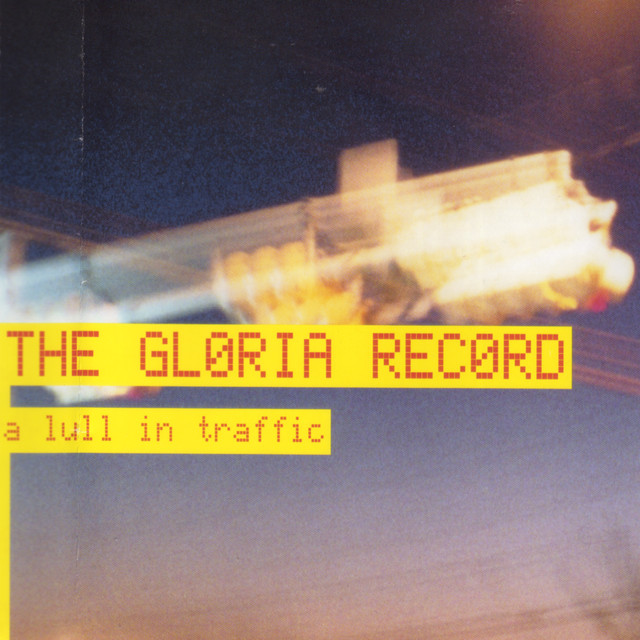 An album cover of a fuzzy picture of the atmosphere at dusk. Text says “THE GL0RIA REC0RD” and “a lull in traffic”