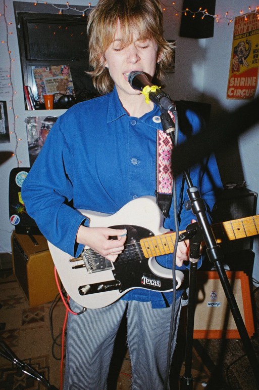 Photo of Miles Ellisor singing into the mic and playing guitar. 