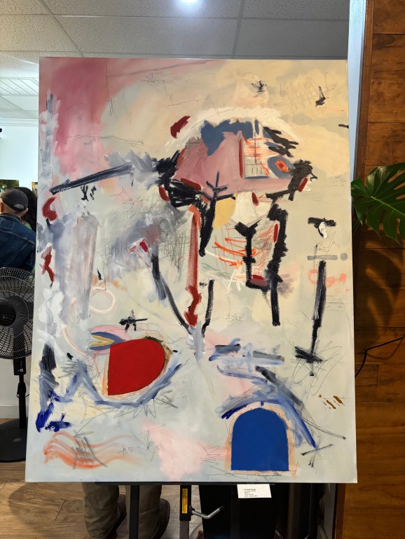 An abstract painting on a large white canvas with different shapes and strokes with multiple colors. 