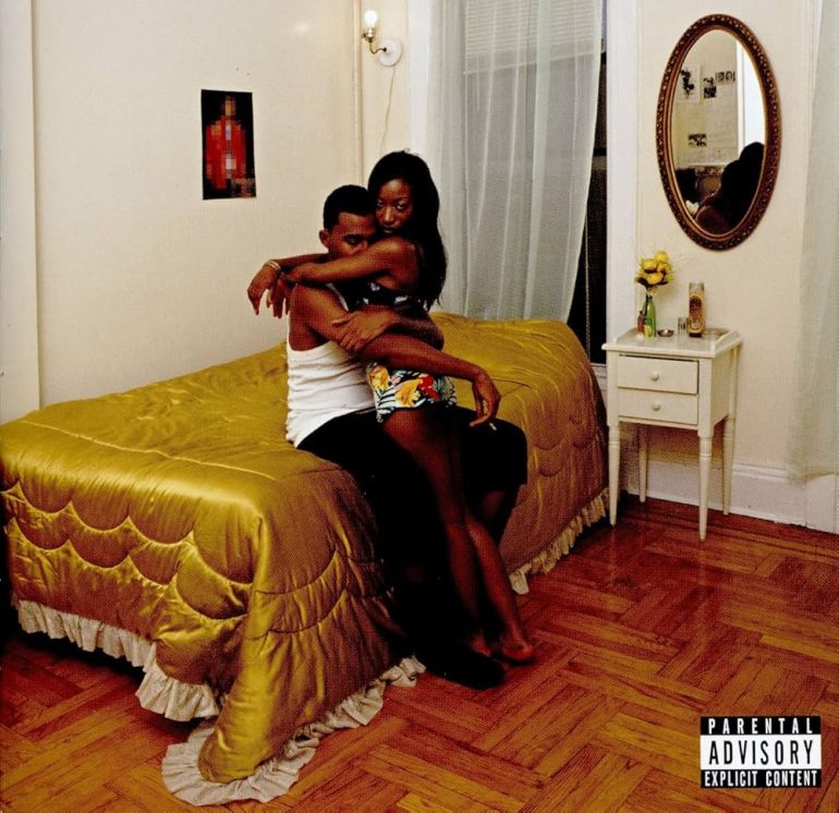 Blood Orange Album cover featuring a young couple embracing sat on a bed