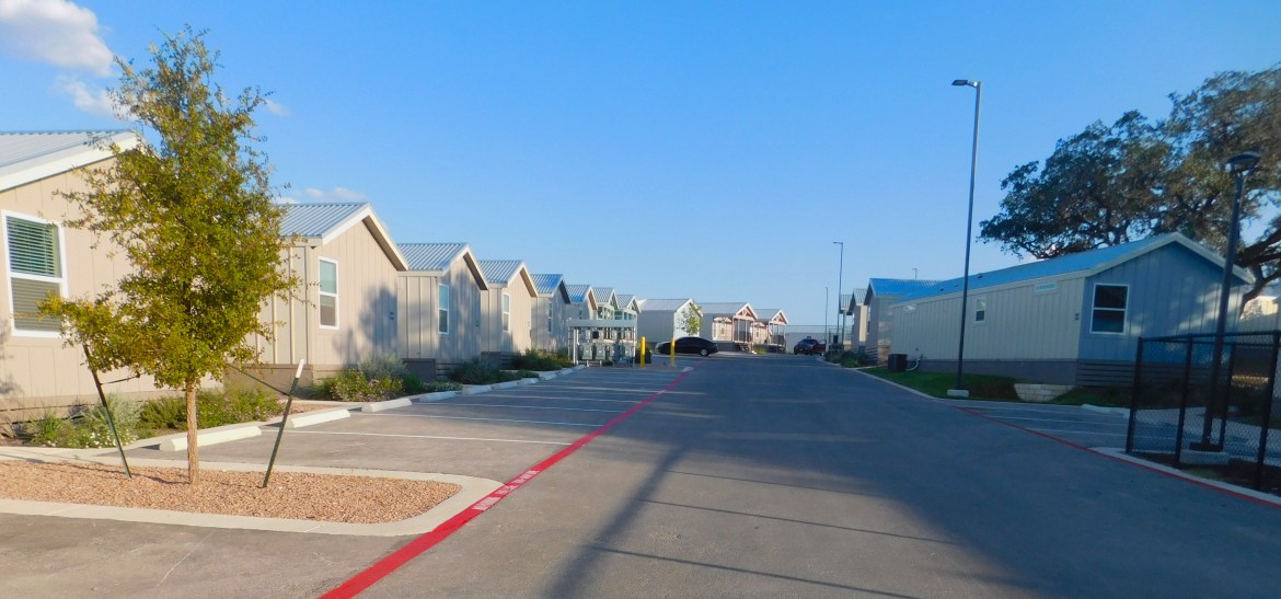 Beige-colored Casata cottages line the street of the property.