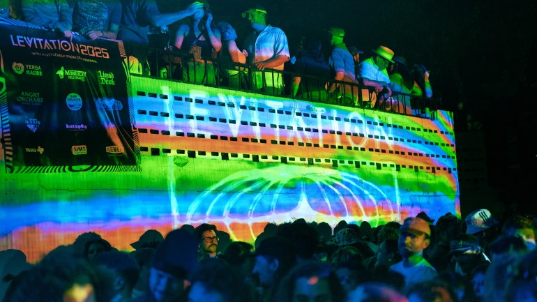 A rainbow display on the wall of the outdoor stage at The Mohawk in Austin, Texas displaying the LEVITATION logo.