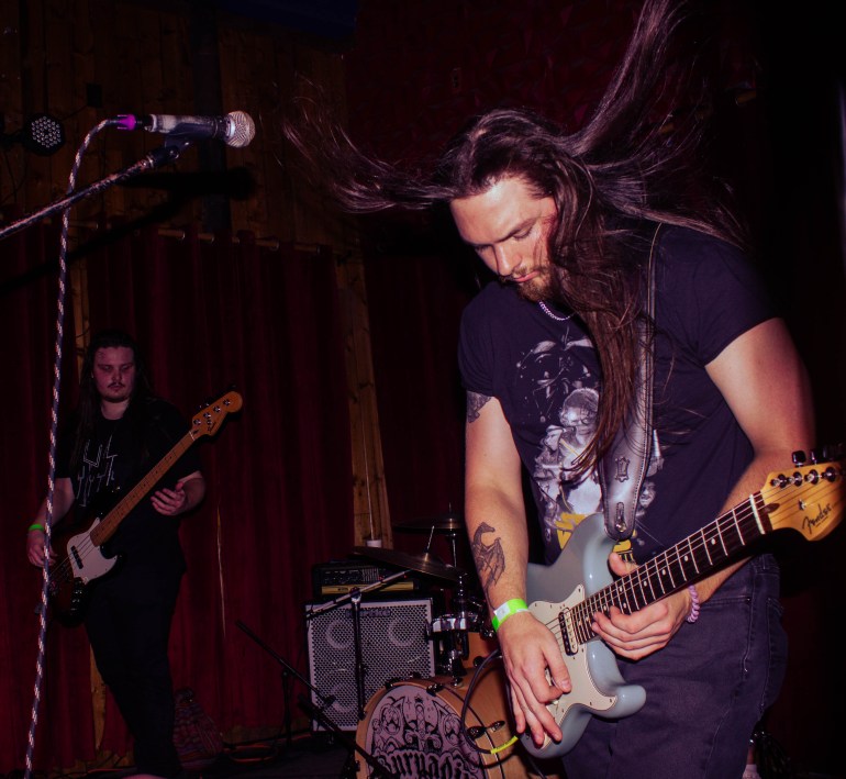 Man Strumming his guitar with hair flowing up