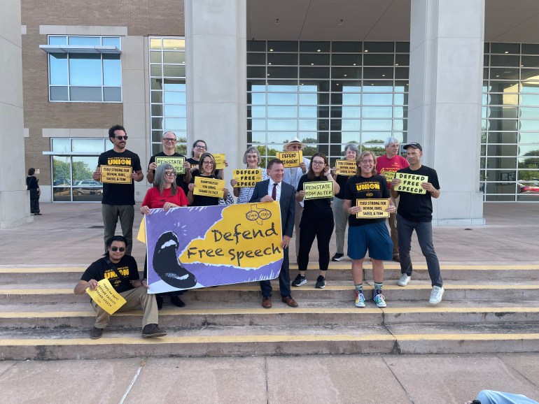 Dr. Tom Alter and Texas State Employee’s Union (TSEU) members gathered outside the Hays County Courthouse, holding signs.