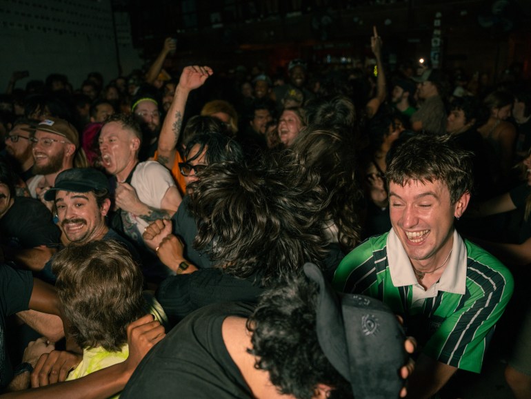 Image of a large crowd with smiling faces and bouncing off of each other while Sweet Pill is playing