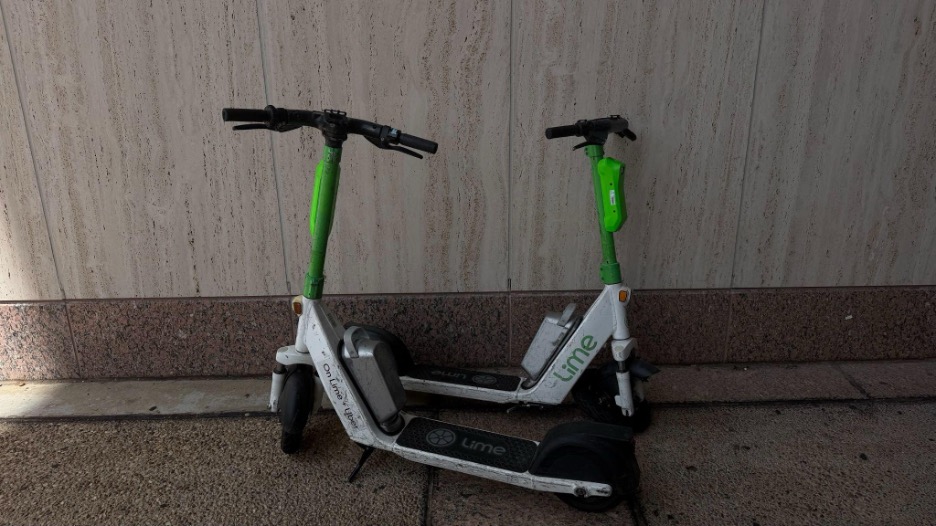 wo rider-less Lime scooters parked outside Alkek Library, on the TXST Campus