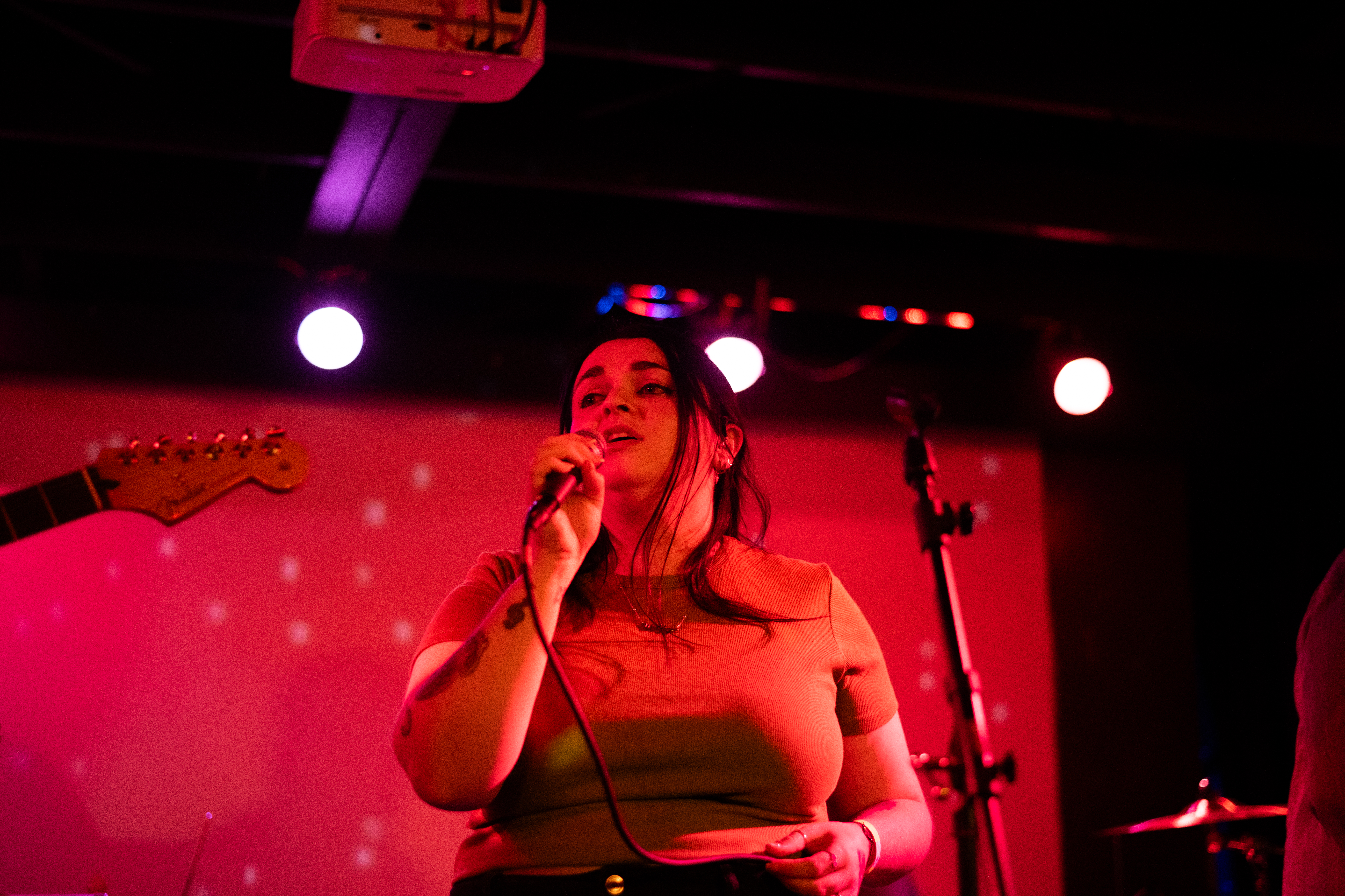 Lead vocalist from Tokyo Tea Room, Beth Dunn, singing into a microphone during thier set. 